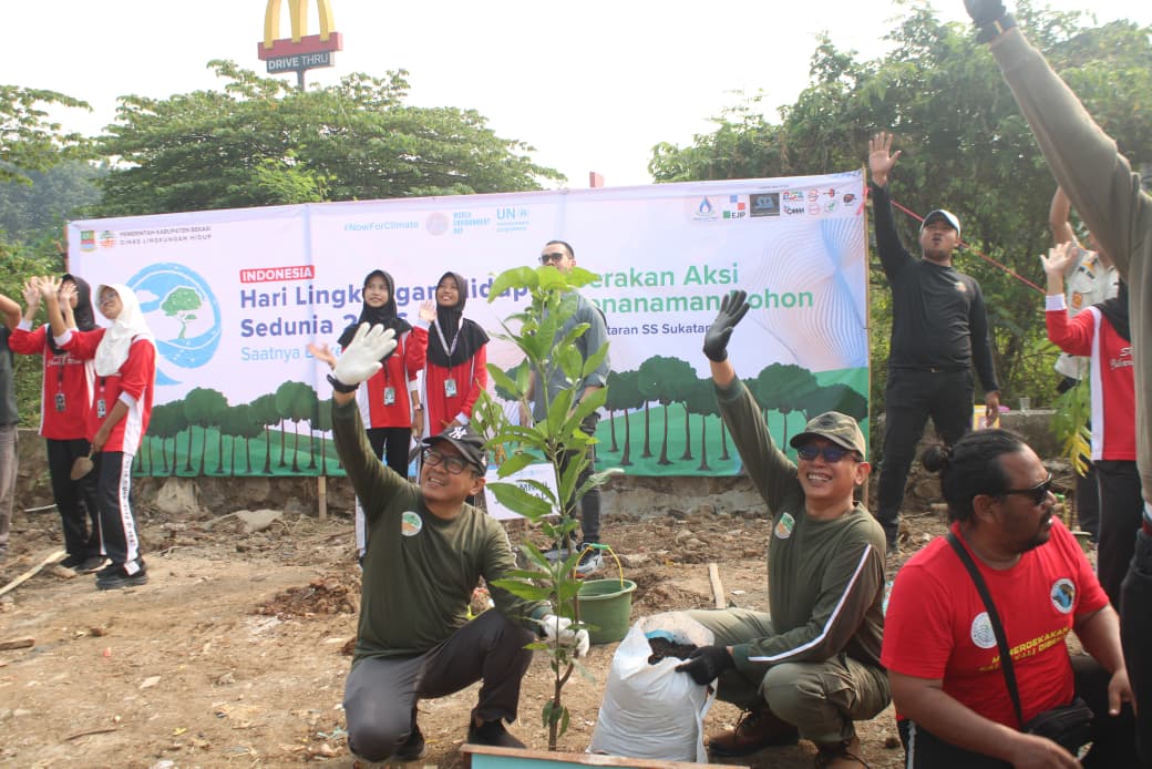 Officials and volunteers planting trees at a greening event in Cikarang Utara